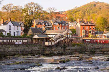 Llangollen, Denbighshire, Galler -21 Nisan 2019: Llangollen şehri manzarası. Dee Nehri 'nde tuğla evler. Bahar mevsimi.