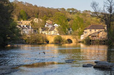 Llangollen, Denbighshire, Galler -21 Nisan 2019: Llangollen şehri manzarası. Dee Nehri 'nde tuğla evler. Bahar mevsimi.