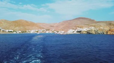 Folegandros, Yunanistan - 26 Eylül 2020 Folegandros Adası Limanı. Rıhtımdaki insanlar, demirli yatlar. Arka planda beyaz binalar.