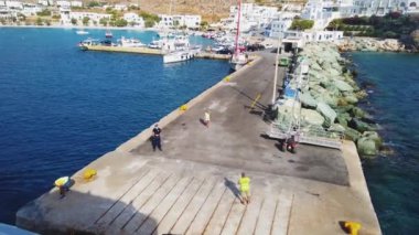 Folegandros, Yunanistan - 26 Eylül 2020 Folegandros Adası Limanı. Rıhtımdaki insanlar, demirli yatlar. Arka planda beyaz binalar.
