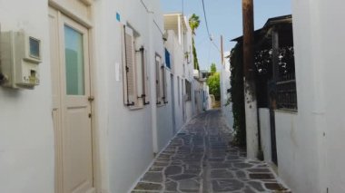 Parikia, Paros Adası, Yunanistan... 26 Eylül 2020, eski şehrin dar sokağı. Geleneksel, geniş mimari ve beyaz eklemli taş bir yol..