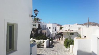 Naoussa, Paros Adası, Yunanistan - 27 Eylül 2020: Balıkçı köyünün dar sokaklarının manzarası. Mavi balkonlu ve panjurlu binaların beyaz cephesi.