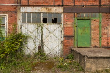 İmparatorluk Tersanesi Patikası. Terk edilmiş salonun yüksek kapısı. İmparatorluk Tersanesi Yolu, Gdansk Tersanesi, Polonya