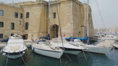Birgu, Malta - 21 Haziran 2021: Malta 'da Birgu ve Valletta arasında feribota binmek. Yat limanda demirli.