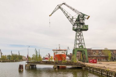 Gdansk, Polonya - 01 Mayıs 2019: İmparatorluk Tersanelerindeki liman vinçlerinin görüntüsü. Rıhtıma demirlemiş gemiler.