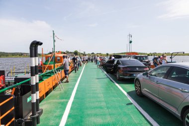 Swibno, Sobieszewska Adası, Polonya - 15 Haziran 2019: Vistula Nehri üzerindeki küçük feribot yolcuları ve arabalar.