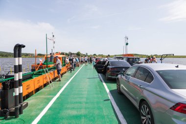 Swibno, Sobieszewska Adası, Polonya - 15 Haziran 2019: Vistula Nehri üzerindeki küçük feribot yolcuları ve arabalar.