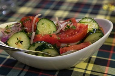 Beyaz tabakta servis edilen taze salata ve salata. Baharatlı mevsimlik Gürcistan sebzeleri. Tiflis, Gürcistan.