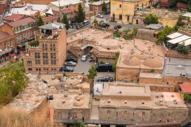 Gürcistan, Tiflis - 30 Ağustos 2019: Eski Tiflis kasabasındaki tarihi binalar. Başkent. Yeraltı hamamlarının tuğlalı çatıları..