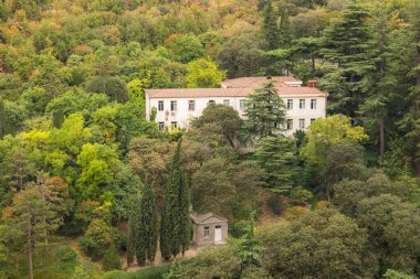 Gürcistan, Tiflis - 30 Ağustos 2019: Gürcistan 'ın başkenti Tiflis tepelerindeki ağaçların arasında beyaz yerleşim yeri.