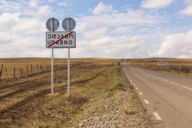 Udabno, Gürcistan - 01 Eylül 2019: Udabno kasabasının adıyla yol tabelası. Steppe arka planda.