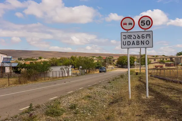 Udabno, Gürcistan - 01 Eylül 2019: Udabno kasabasının adıyla yol tabelası. Steppe arka planda.