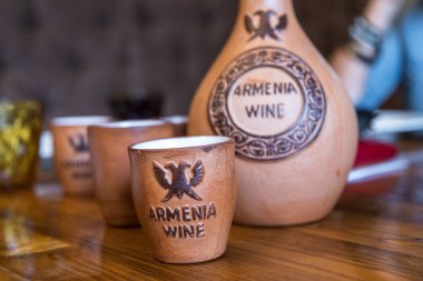 Goris, Armenia - 03 September 2019: Traditional Armenian wine in ceramic jug and cup. Armenian restaurant. clipart