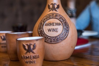 Goris, Armenia - 03 September 2019: Traditional Armenian wine in ceramic jug and cup. Armenian restaurant. clipart