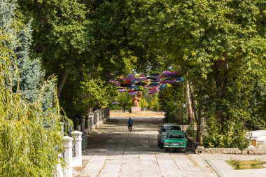 Stepanakert, Nagorno-Karabakh, Azerbaycan 04 Eylül 2019: Stepanakert kasabasının merkezi, renkli şemsiyeler altında arabalar. Parka girin.