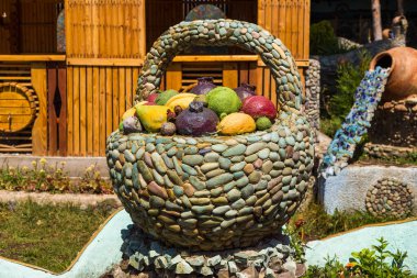 Restoranın önündeki dekorasyon. Renkli meyveli taş sepet. Gölün kıyısındaki küçük kasaba Sevan 'da. Arkaplanda bina.