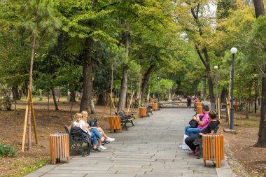 Tiflis, Gürcistan - 06 Eylül 2019: Parktaki banklarda dinlenen insanlar. Tiflis 'in merkezinde yeşil alanlar.
