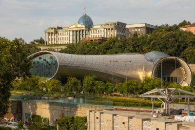 Tiflis, Gürcistan - 06 Eylül 2019: Eski Tiflis kasabasındaki Kura (Mtkvari) nehrinin manzarası. Tören Sarayı, bir tepenin üstünde Gürcistan Başkanı 'nın evi..