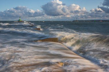 Güneşli bir günde Baltık Denizi 'nde Yeşil Deniz Feneri ve Beton Kırık Su Sahili. Gdansk, Polonya.