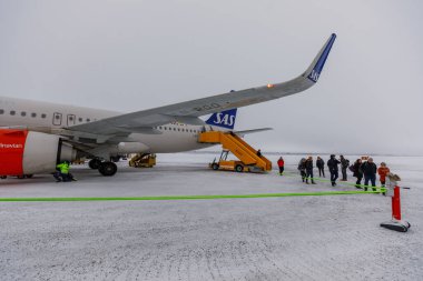 Kiruna, İsveç - 30 Ocak 2020: SAS havayollarından inen yolcular. Kış mevsimi. Havaalanı pistinde kar var..