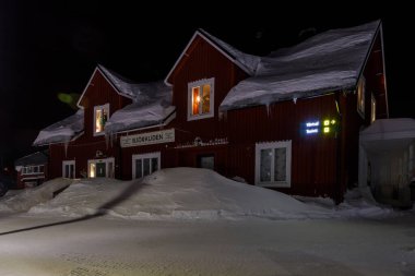 Bjorkliden, İsveç - 31 Ocak 2020: Bjorkliden tatil köyündeki karla kaplı tren istasyonu. Kış akşamı.