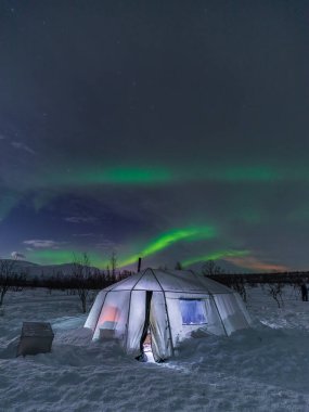 Aurora Borealis, Kuzey Işıkları Abisko Ulusal Parkı 'nda. Karlı açıklıkta ışıklı çadır. Laponya, İsveç.