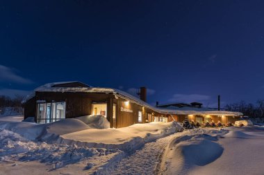 Kiruna, Lapland, İsveç - 03 Şubat 2020: Mattarahkka Kuzey Logosu manzarası. Güzel karlı kış. Kar araçları binanın önüne park edilmiş. İsveç.