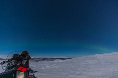 Kiruna, Laponya, İsveç - 04 Şubat 2020: Kuzey hafif Laponya. Kar motosikletli turistler.