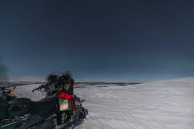 Kiruna, Laponya, İsveç - 04 Şubat 2020: Kuzey hafif Laponya. Kar motosikletli turistler.