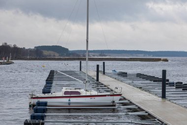 Baltık Denizi kıyısında ahşap bir iskelesi var. Gemi demirli. Bahar sezonu. Kivik, Scania, İsveç.