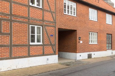 Ystad, İsveç - 7 Mart 2020: Yarı ahşap desenli tuğla bina cephesi ve iskan caddesinde geçiş.