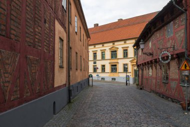Ystad, İsveç - 7 Mart 2020: Eski kasabada sakin bir kaldırım taşı caddesi boyunca geleneksel yarı keresteli binalar.