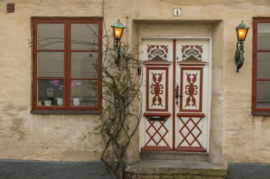 Ystad, İsveç 'te dekoratif kırmızı ve beyaz çift kapılı geleneksel cephe, antika fenerler ve pencereler.