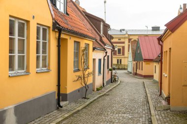 İsveç 'in Ystad şehrinde renkli küçük evleri ve kaldırımları olan büyüleyici dar bir cadde. Sessiz şehir manzarası.
