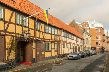 Ystad, İsveç - 7 Mart 2020: Kereste çerçeveli geleneksel otel binası, yeşil pencereli ve girişte İsveç bayrağı.