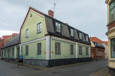 Ystad, İsveç - 7 Mart 2020 Ystad 'da sakin bir sokak köşesinde iki katlı yeşil bina.