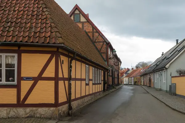 İsveç 'in eski Ystad kentindeki renkli cephe ve pencerelerle dolu sessiz kaldırım taşı caddesi.