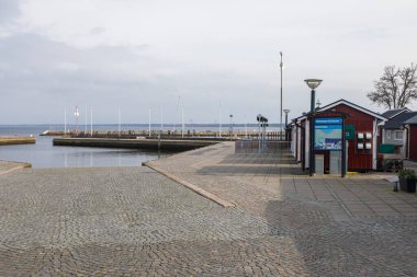 Torekov, İsveç - 8 Mart 2020: Bulutlu bir öğleden sonra tabela, restoran ve ağaçlı liman bölgesi.