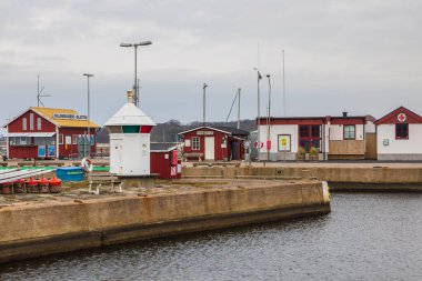 Torekov, İsveç - 8 Mart 2020: Bulutlu bir öğleden sonra tabela, restoran ve ağaçlı liman bölgesi.