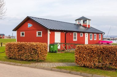 Torekow İsveç 8 Mart 2020: Kırmızı ahşap bina ve liman yakınlarındaki kamusal ızgara alanı.