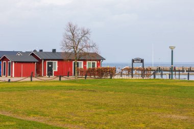 Torekow İsveç 8 Mart 2020: Kırmızı ahşap bina ve liman yakınlarındaki kamusal ızgara alanı.
