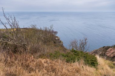 İsveç 'in Kullen kentindeki uçurumların kenarında küçük beyaz bir deniz feneri bulunan dramatik kayalık kıyı şeridi..