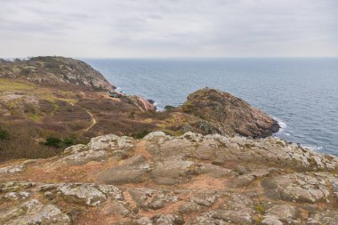 İsveç 'in Kullen kentindeki uçurumların kenarında küçük beyaz bir deniz feneri bulunan dramatik kayalık kıyı şeridi..