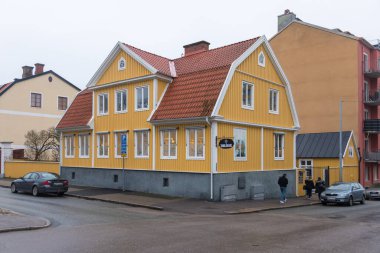 Karlskrona, İsveç 9 Mart 2020: Carlings mağazası, dekore edilmiş ağaç ve tarihi bir binanın saat kulesi ile sokak manzarası.