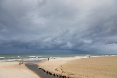 Karwia, Polonya 13 Eylül 2020: Baltık Denizi üzerinde toplanan fırtına bulutları insanlar boş sahil boyunca yürürken.