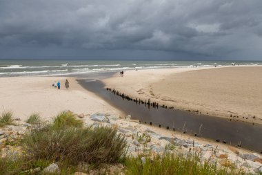 Karwia, Polonya 13 Eylül 2020: Baltık Denizi üzerinde toplanan fırtına bulutları insanlar boş sahil boyunca yürürken.