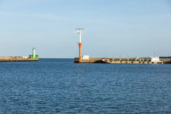 Wladyslawowo, Polonya 13 Eylül 2020: Güneşli bir günde yeşil bir deniz feneri ve radar istasyonu olan liman girişinin görüntüsü.