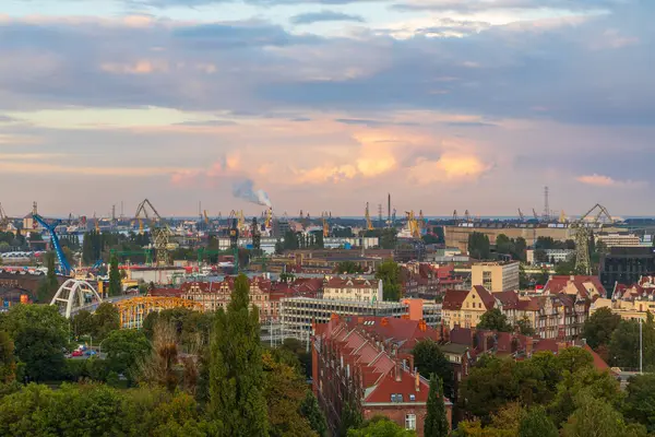 Gdansk, Polonya 7 Ekim 2020: Tersane vinçleri, duman yığınları ve kırmızı çatılı apartman binaları ile Gdansk 'ın sanayi manzarası.