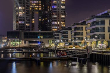 Gdynia, Polonya 22 Kasım 2020: Aydınlatılmış Deniz Kuleleri ve konut binalarıyla gece limanı.