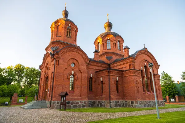 Bialowieza, Polonya - 3 Haziran 2021: Kırmızı tuğla kuleleri, kubbeleri ve gün batımında dekoratif pencereleri olan Ortodoks kilisesi.